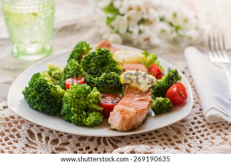 Salmon teriyaki served with broccoli, tomatoes and lemon. Selective focus on the fish