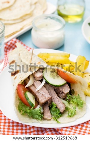 Greek gyros with pork, vegetables, potatoes and homemade pita bread. Selective focus