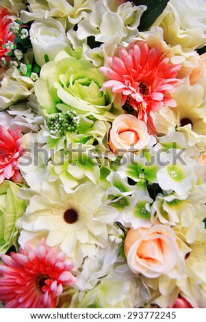 A bouquet of mixed pink flowers including roses, lilies and chrysanthemums with white gypsophila.
