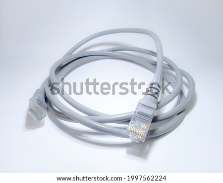 Lan cable for internet network connection, gray lan cable on a white background. Ethernet cable for computer or laptop with rj45 connector closeup. Hand holding LAN cable close-up. Imagine de stoc © 