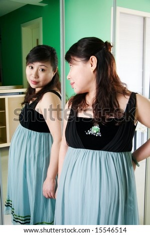 pregnant woman standing in front of mirror.