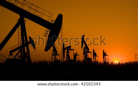 Silhouette of oil field with sunset