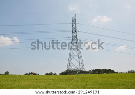 electricity power pylon in the green grass golf club