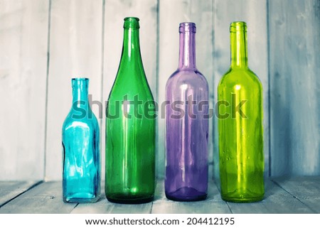 Photo of multi colored bottles on wooden background