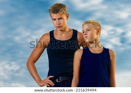 Two teenagers on the beach. Looks thoughtfully into the distance. The sky in the background. Summer vacation concept.