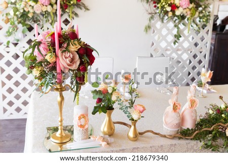 Floral arrangement to decorate the wedding feast, the bride and groom. Flowers, candles, a bottle of champagne. The vintage.