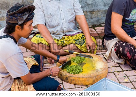 Bali, Indonesia, May 3, 2015. Unidentified balinese men prepare a meal for the feast at the local temple in Bali, Indonesia.