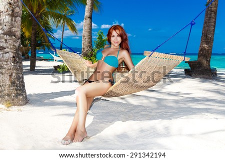 Young lady relaxing in hammock on the tropical beach