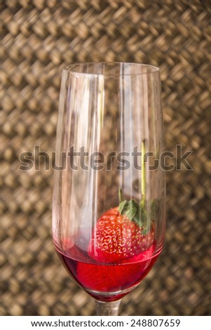 Strawberry berries and red water in a glass of wine.
