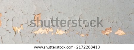 Peeling paint on the wall. Panorama of a concrete wall with old cracked flaking paint. Weathered rough painted surface with patterns of cracks and peeling. Wide panoramic texture for grunge background Foto stock © 