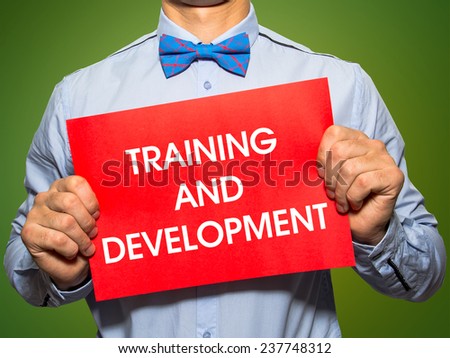 Man holding a card with the text Training and development on white background