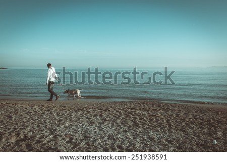 Guy walk along the shore of a tropical beach with a dog. Book cover