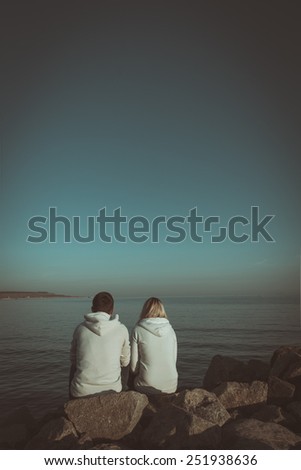 Loving couple sitting on the sea shore. Book cover
