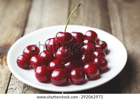Ripe cherries on a plate on the table, vintage