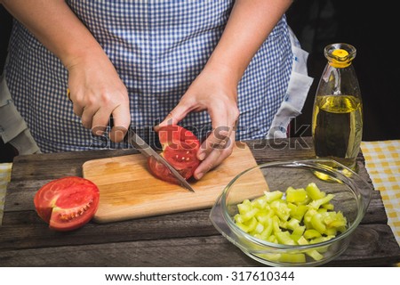 Preparation of vegetable salad on the wooden background. Cutting vegetables