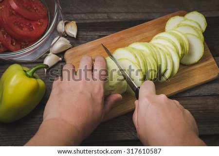 Preparation of vegetable salad on the wooden background. Cutting vegetables