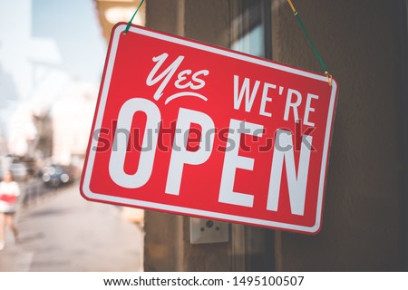 yes we're open sign on the glass of the doors in store.  welcome sign at the store 商業照片 © 