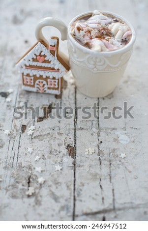 Vintage mug of Cocoa with marshmallows hot drink with gingerbread cookie and cinnamon sticks and anise stars on a white shabby table