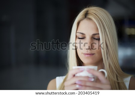 woman drinking coffee in the morning eyes closed ( small depth of field, focus on closed eyes)