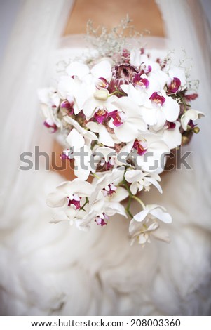 Bride holding wedding bouquet. Focus is on flowers. Small depth of field