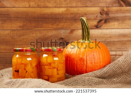 Preserved autumn vegetables on shelf in wooden wall