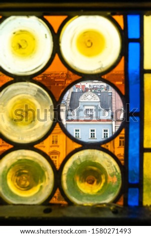 Panorama of Krakow's Old Town through the colorful stained glass window of the Town Hall Tower. In transparent Circle - tenement house 'Kamienica Pod Jagniemi' Zdjęcia stock © 