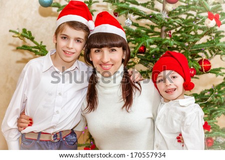 Family near The Christmas Tree wearing Santa\'s Hat