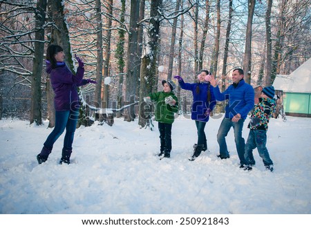 Family having snowball fight in snow in winter background