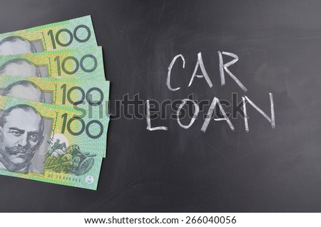 A number of one hundred Australian dollar notes on a blackboard where Car Loan is handwritten in white chalk