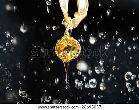 Yellow precious jewel in the fine drops of rain isolated on black