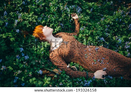 Beautiful young woman in the forest with spring flowers