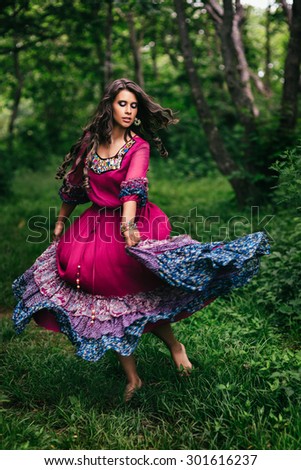 Portrait of a beautiful girl gypsy in violet dress