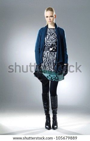 full-length fashion model holding little purse posing on light background