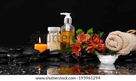 Spa still life with red orchid, massage oil, candle and , stones,salt in bowl