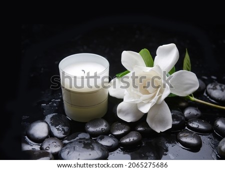 Zen lifestyle, still life of with
Spa ball, candle,, gardenia and zen black stones, on wet background

