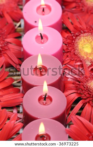 Row of candles with sunflower on straw mat