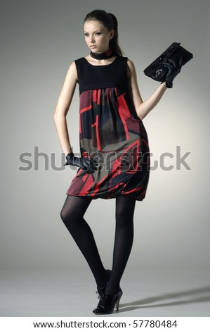 fashion photo of young woman holding little purse shot in studio