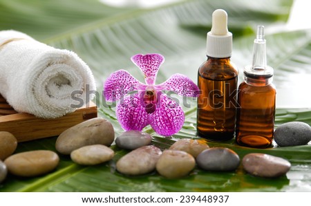 spa supplies with orchid, oil, towel,on banana leaf