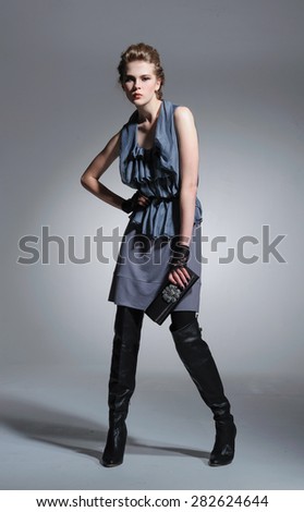 full-length fashion two model in coat clothes with purse posing on light background