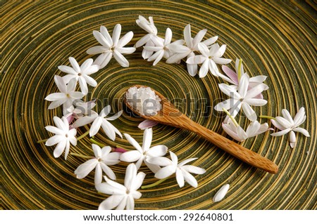 Many white flower with soap, salt in spoon in wooden bowl