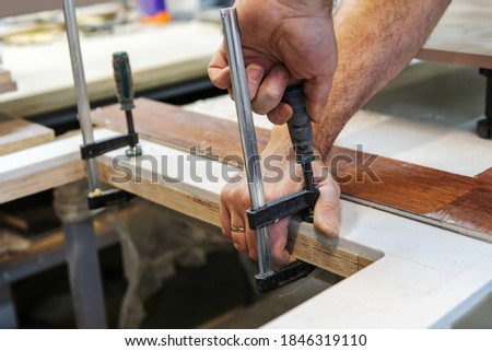 Image, Stock Photo Crop woodworker applying adhesive on plank for longboard