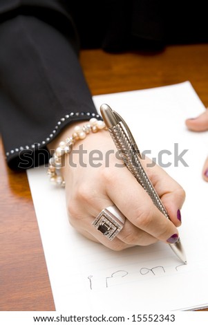 Closeup of a stylish woman writing a note in Arabic
