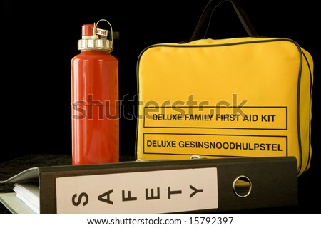 Yellow first aid kit, red halon fire extinguisher and safety file. Focus on yellow kit