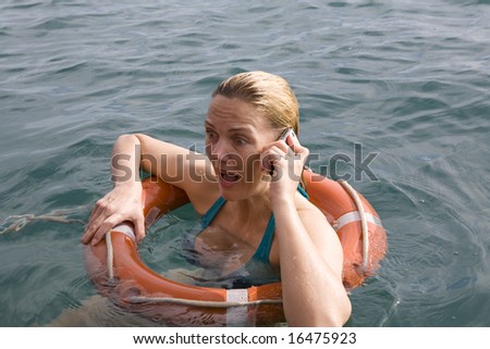 Female in water using a lifebuoy and mobile phone in an emergency situation