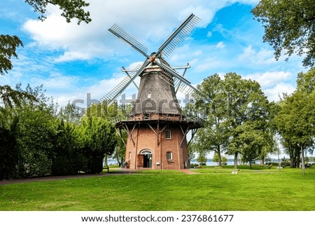 Similar – Image, Stock Photo Windmill at the lower edge of the picture in silhouette form and sky with contrails