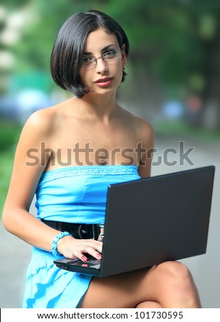 Young woman - business lady, working with laptop outdoors