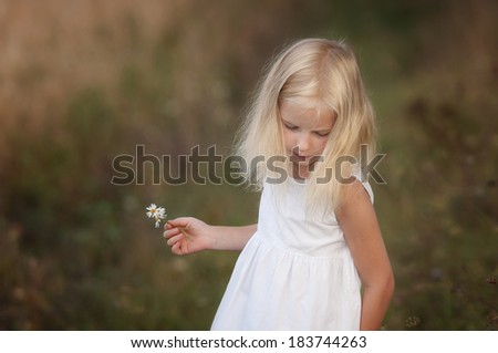 Little cute girl walks in the summer field. Happiness, joy, dance and smile.