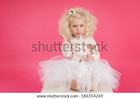 Little girl with candy on pink background skirt tutu.  Sweet, princess, beauty.