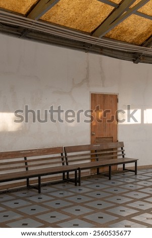 Similar – Image, Stock Photo Plain wooden bench in front of a wooden wall, with a window barricaded with square timbers.