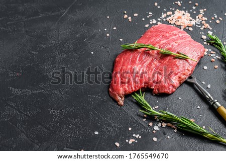 Raw Flat iron steak with rosemary and pink salt. Fresh Marble beef meat black Angus. Black background. Top view. Copy space ストックフォト © 